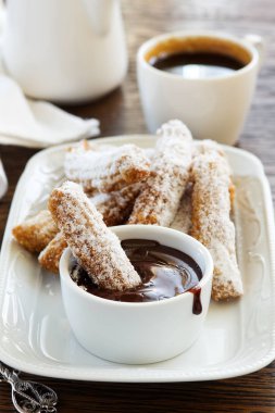 Churros sıcak çikolata ve pudra şekeri ile.