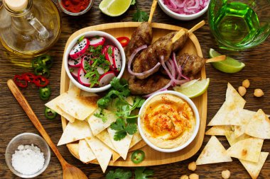 Kyufta (Barbekü) aperatifler (turp salatası, cips ve humus ile kuzu.)