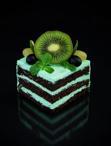 A piece of chocolate mint cake on a black background.