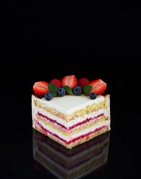 Piece of cake with strawberries on a black background.