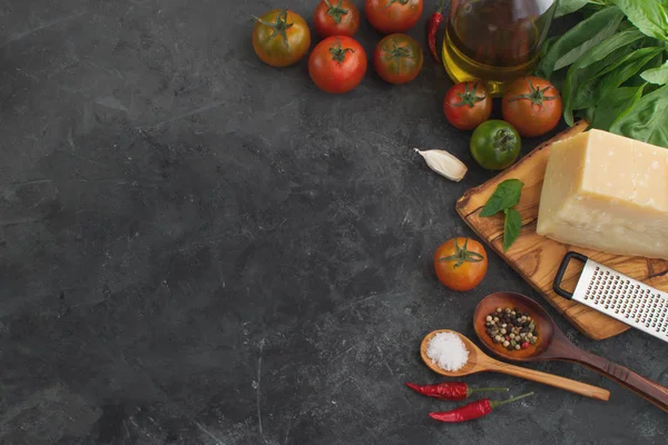 Fresh tomatoes with spices and cheese top view on dark concrete background, copy space