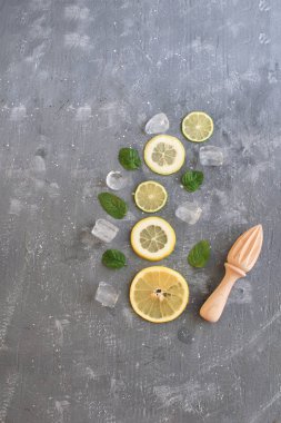 Yaz arka plan narenciye limonata kavramı Narenciye Nane yaprakları ve buz küpleri ile gri arka plan üstten görünüm kopya alanı dilimlenmiş.