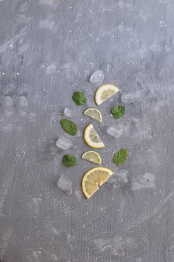 Yaz arka plan narenciye limonata kavramı Narenciye Nane yaprakları ve buz küpleri ile gri arka plan üstten görünüm kopya alanı dilimlenmiş.