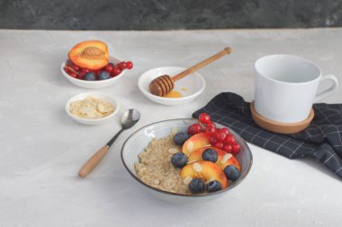 Şeftali, yaban mersini, frenk üzümü ve badem gri beton arka plan kopya alanı natürmort yaz kahvaltı sağlıklı bir kahvaltı kavramı yulaf ezmesi