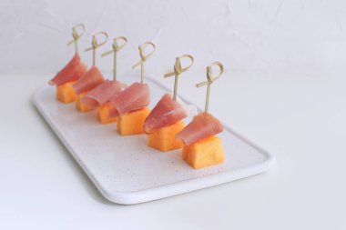 Jamon üzerinde kurulu Restoran gurme yemek geleneksel İtalyan İspanyol Meze tapas beyaz arka plan kopya alanı doğrama porselen ile şiş Melong üzerinde prociutto kanepeler ile kavun