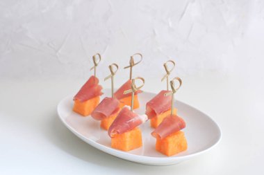 Jamon üzerinde beyaz porselen plaka restoran gurme yemek geleneksel İtalyan İspanyol Meze tapas beyaz arka plan kopya alanı ile şiş Melong üzerinde prociutto kanepeler ile kavun