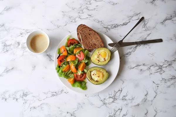 Sağlıklı beslenme kavramı Baked avokado Bıldırcın yumurta domates salat ve ekmek Cappucino Kupası Kahvaltı Brunch diyet yemek düşük carb üst düz yatıyordu mermer arka plan kopya alanı göster