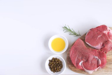 Taze çiğ et Dana biftek zeytin yağı kavramı yemek kavramı beyaz arka plan üstten görünüm kopya alanı düz baharat biber biberiye pişirme yatıyordu