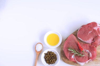 Taze çiğ et Dana biftek zeytinyağı düz yatıyordu baharat sıcak tuz tahta kaşık Biberiye Biber yemek kavramı yemek kavramı beyaz arka plan üstten görünüm kopya alanı