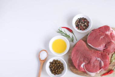 Taze çiğ et Dana biftek zeytinyağı düz yatıyordu baharat sıcak tuz tahta kaşık Biberiye Biber yemek kavramı yemek kavramı beyaz arka plan üstten görünüm kopya alanı