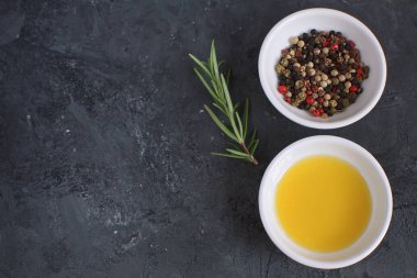 Zeytinyağı porselen tabak biberiye dalı biber karışımı yemek kavramı baharat baharat siyah beton arka plan üstten görünüm kopya alanı düz yatıyordu