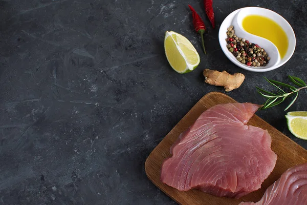 Ham orkinos biftek ahşap cutboard kireç dilim zeytin yağı Rosemary Fresh zencefil kökü Chili biber karışımı siyah beton arka plan kopya alanı üstten görünüm yemek madde Asya gıda düz düşük anahtar yatıyordu