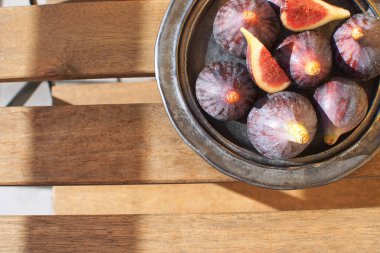 Ahşap masa Sunligh kopya alanı sonbahar sonbahar üst hasat seramik siyah plaka üzerinde taze incir görüntülemek