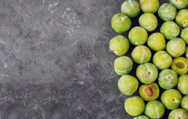 Lezzetli olgun yeşil erik Greengages siyah dokulu beton arka plan kopya alanı düz hasat sonbahar yatıyordu