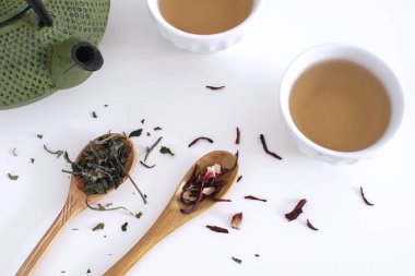 Kurutulmuş hibiscus beyaz arka plan kopya alanı düz yatıyordu çay töreni demir çaydanlık bardak tahta kaşık çay yaprakları