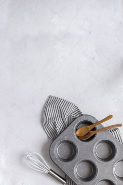 Pişirme için-mutfak eşyaları Cupcake metal kalıp, çırpma teli, tahta kaşık buruşuk çizgili peçete üzerinde. Üstten görünüm, düz lay, kopya alanı. En az resim.