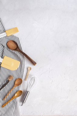 Kavram - çırpma teli, tahta kaşıklar, silikon spatula, fırça, vanilya çekirdeği üzerinde çizgili peçete buruşuk kötek pişirme için mutfak eşyaları. Üstten görünüm, düz lay, kopya alanı.