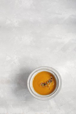 En az bir resim - kabak çorbası plaka üstten görünüm, gri arka plan, kopya alanı.