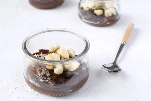 Sağlıklı beslenme - avokado cam üst, yakın çekim, beyaz arka plan, kopya alanı macadamia fındık ile yapılan vegan çikolatalı puding. Menü tasarımı