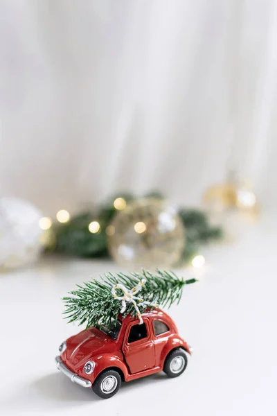 Noel kompozisyon, yeni yıl - Noel ağacına çatı, kağıt house, tinsel, oyuncak geyik, garland ile oyuncak kırmızı araba. Yaratıcı kış dekorasyon, beyaz arka plan, kopya alanı.