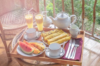 Güzel teras ya da balkon, Otel Oda Kahvaltı, çare - taze karpuz, mango, muz, güler yüzlü, krep, Çaydanlık, bardak, rattan koltuk