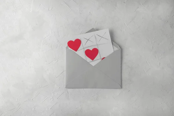 バレンタインの日手作りグリーティング カード 灰色封筒 白いコンクリート背景と Tic Tac つま先のゲーム — ストック写真