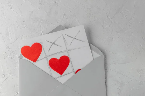 バレンタインの日手作りグリーティング カード 灰色封筒 白いコンクリート背景と Tic Tac つま先のゲーム — ストック写真