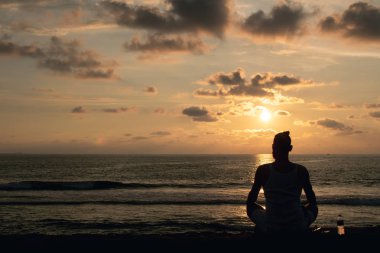 Tropikal beach paradise - genç adam siluet, günbatımı okyanus üzerinde meditasyon tadını hipster