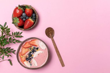 Arka plan bahar diyet, vücut detoks, sağlıklı kahvaltı kavramı, yaşam tarzı blog - Hindistan cevizi kase meyve güler yüzlü, taze çilek, yaban mersini, Hindistan cevizi cips, üstten görünüm, pembe