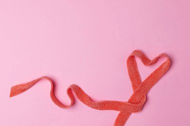 Sevgililer kadın anneler günü kavramı 8 Mart - kalp yapılan ekşi şeker rulo, kırmızı kurdele, pembe bir arka plan, kopyalama alanı