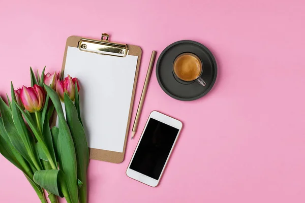 Sevgililer kadın anneler günü kavramı 8 Mart bahar, yaşam tarzı blog - pembe laleler, Pano boş kağıt, kalem, espresso kahve, pembe bir arka plan, kopya alanı, smartphone ile ana sayfa görünümü