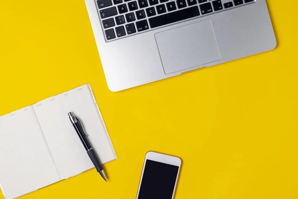 Çalışma alanı serbest meslek, blogger, gazeteci - dizüstü bilgisayar, Not defteri, kalem, kahve Kupası, parlak sarı arka plan, üstten görünüm, düz lay, smartphone kopyalama alanı