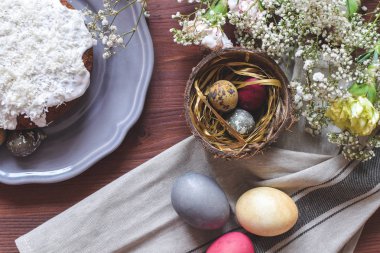 Paskalya kutlamaları - seçici odak Paskalya kek ve renkli Paskalya yumurtaları Hindistan cevizi kabuğu, gypsophila çiçekler, karanfil dekore edilmiş