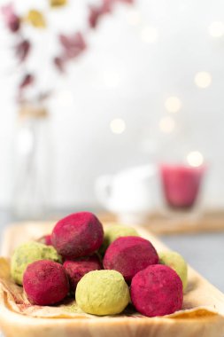 Matcha yeşil çay ve pembe ahududu pancar truffles tarih seçici odak, beyaz arka plan kapatmak, uzay - kopya gurme sağlıklı tatlı, üstten görünüm, bokeh arka plan
