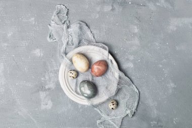 Oranic doğal Paskalya kavramı, rustik tarzı - doğal olarak boyalı Paskalya yumurta, bıldırcın yumurtası seramik tabak, curcuma, beetrooot, ebegümeci çayı, gri arka plan, kopya alanı