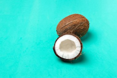 Olgunlaşmış hindistancevizi ve parlak mavi arka plan, minima yarım Hindistan cevizi