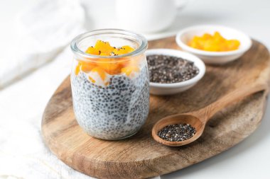 Badem sütü ve mango beyaz ba üzerinde cam kavanoza Chia puding