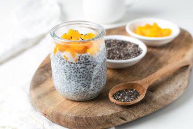 Badem sütü ve mango beyaz ba üzerinde cam kavanoza Chia puding