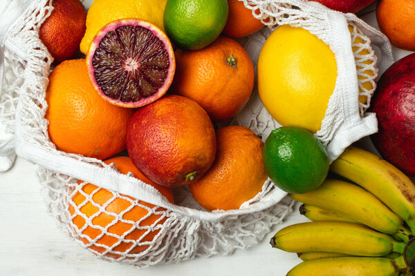 Organic citrus fruits variety in cotton mesh reusable shopping b