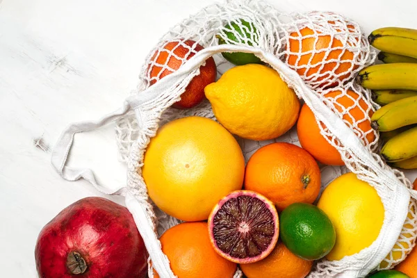 Organic citrus fruits variety in cotton mesh reusable shopping b