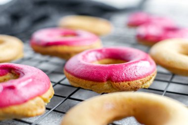 Ev yapımı pişirme-parlak pembe krema ile taze pişmiş Donuts 