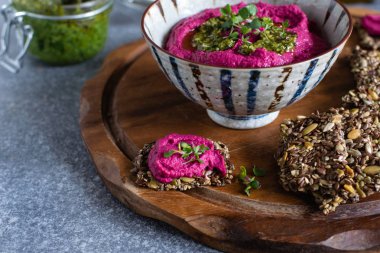 Seramik kase içinde Kavrulmuş Pancar Humus, woode üzerinde keten tohumu kraker