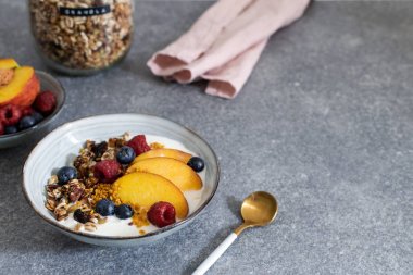 Granola yoğurt taze şeftali, yaban mersini, taba üzerinde ahududu ile