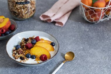 Granola yoğurt taze şeftali, yaban mersini, taba üzerinde ahududu ile