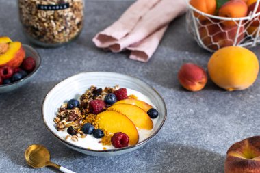 Granola yoğurt taze şeftali, yaban mersini, taba üzerinde ahududu ile