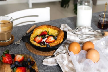 Taze çilek, cappuccino bir fincan ile Hollandalı bebek pancake