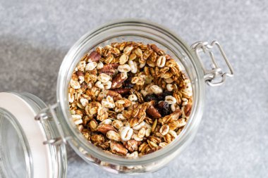 Cam kavanozda pekan fındık ile ev yapımı granola, seçici odak, 
