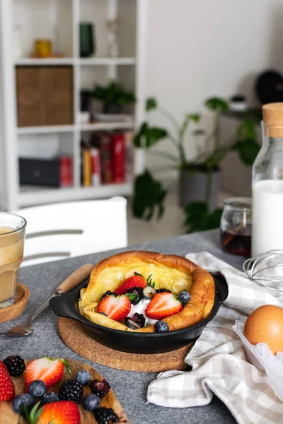 Голландский блинчик со свежими ягодами, чашка капучино — стоковое фото