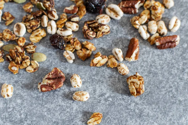 Organic homemade granola with pecan nuts on gray table, top view — Stock Photo, Image