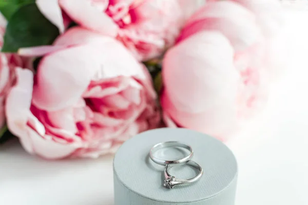Anéis de casamento, envelope, flores de peônias no fundo branco, co — Fotografia de Stock